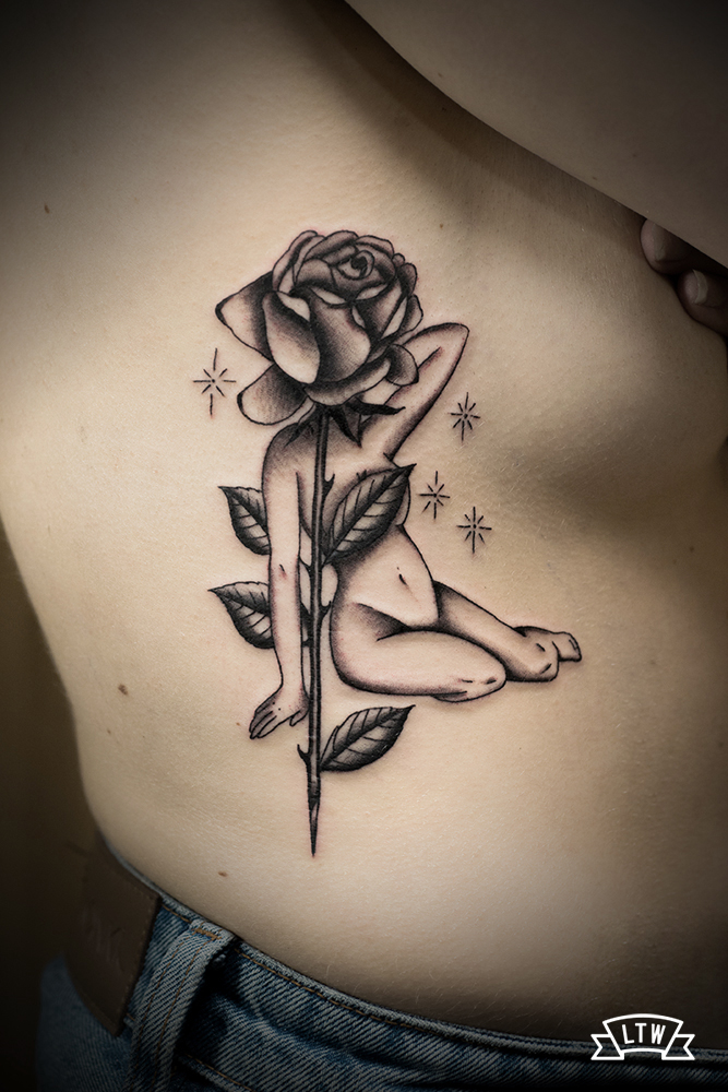 Rose with a woman body tattooed by Dani Cobra in black and grey