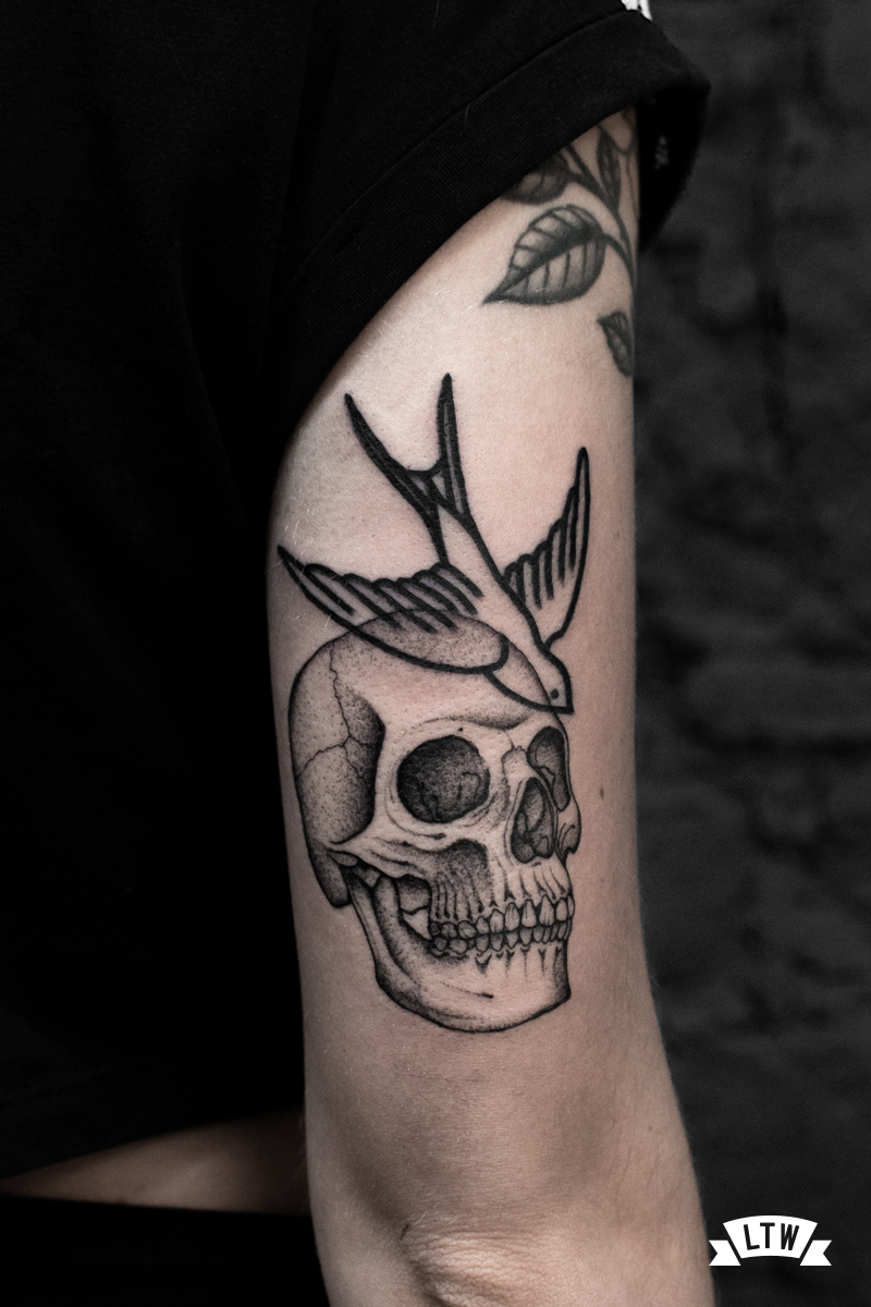 Swallow and skull tattooed by Dani Cobra in black and grey