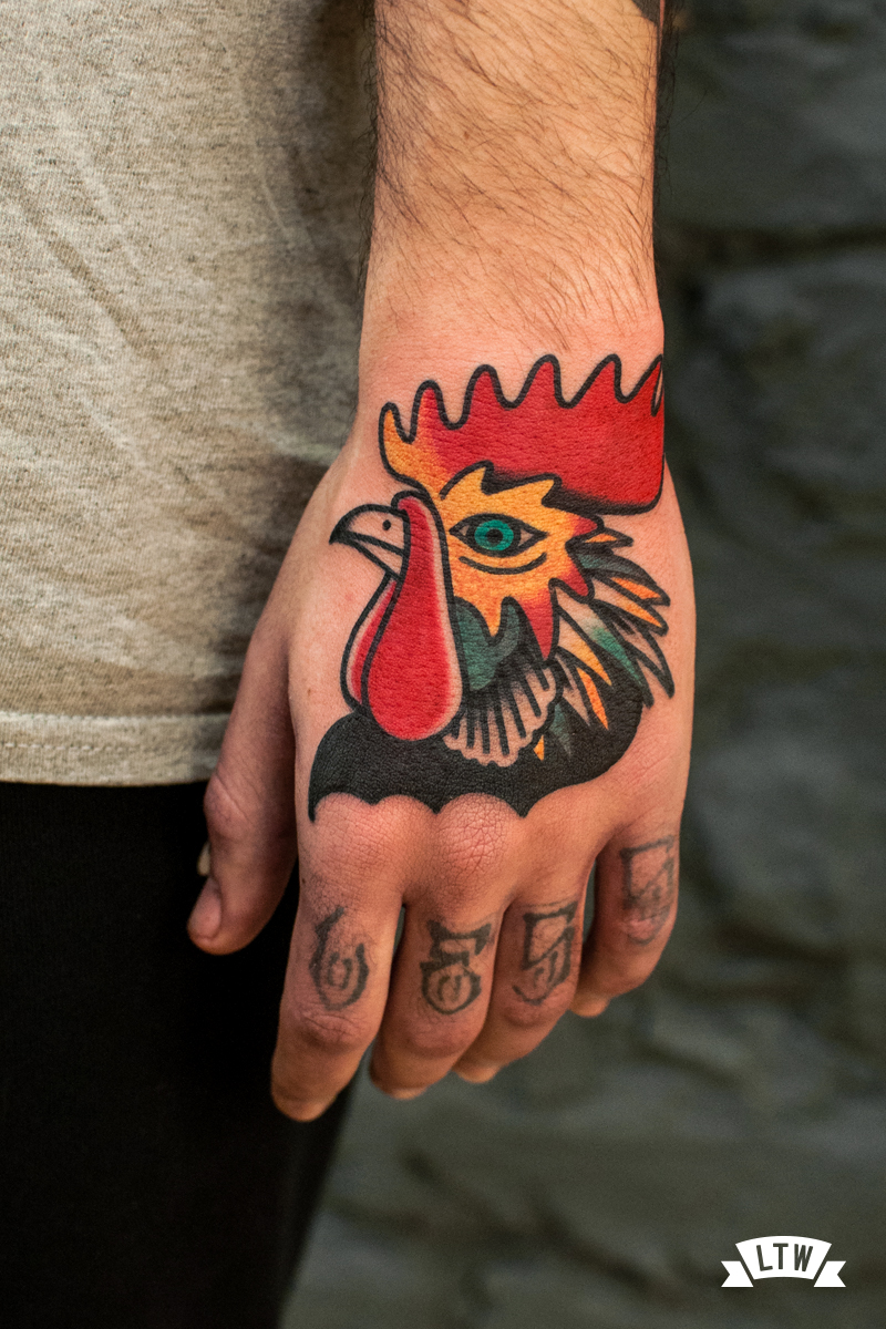 Gallo tatuado en mano por Javier Rodríguez