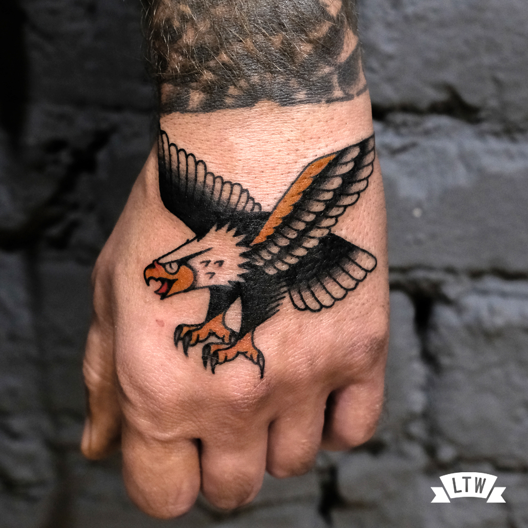 Eagle tattooed on a hand by Dennis