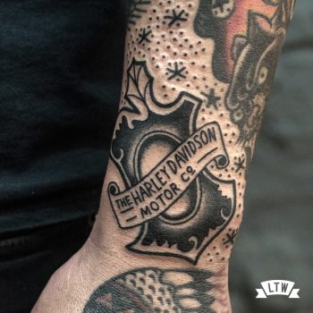 Harley Davidson shield tattooed in black and white by Dennis